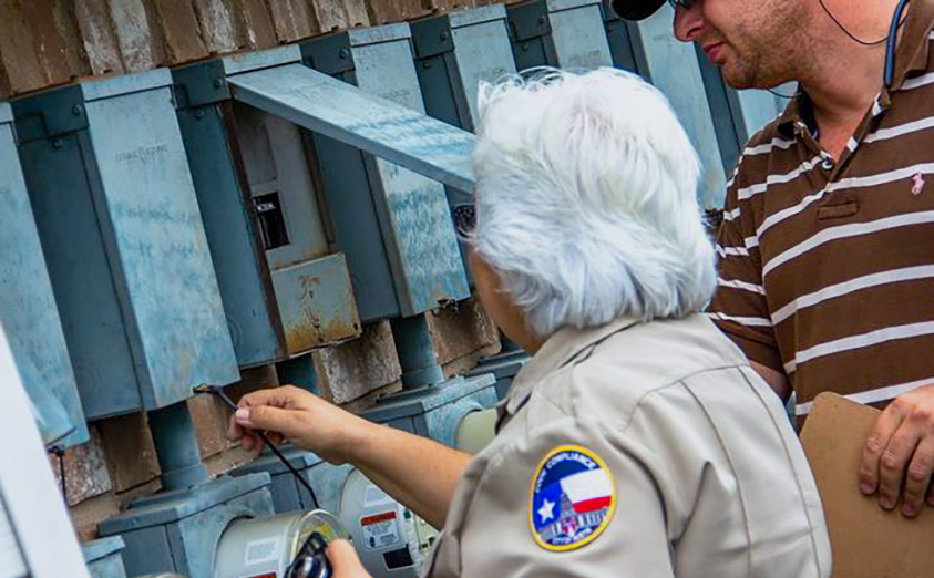 Code officer inspecting exterior electrical panels